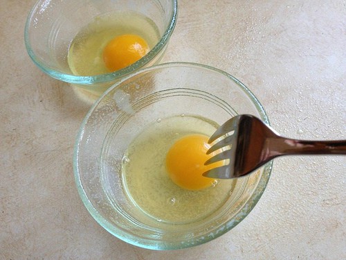 Fork breaking yolk for 1 Minute Egg Salad.