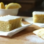 Gluten-free lemon cake squares on wood board.