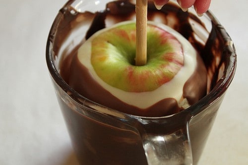 Dipping apple in dark chocolate.