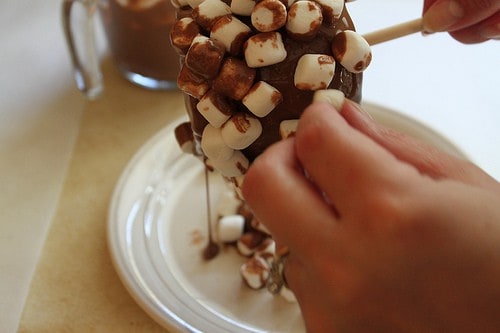 Placing marshmallows on chocolate dipped apple.