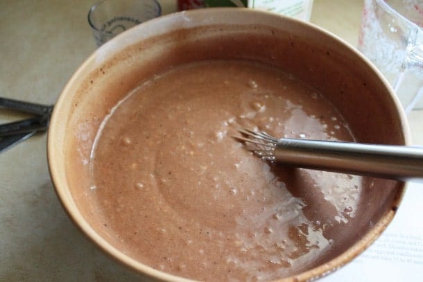 Batter for gluten-free cola cake in wood bowl.