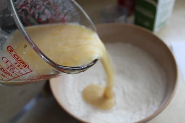 Adding eggs and buttermilk to gluten-free cola cake batter.