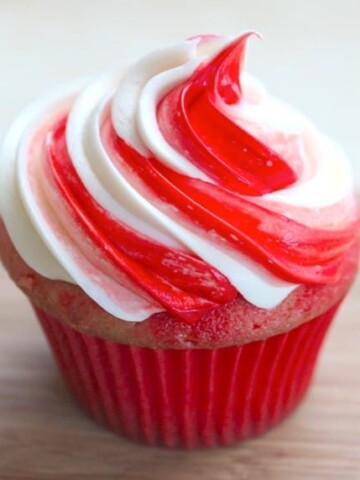 Cupcake frosted with red and white swirl of frosting.