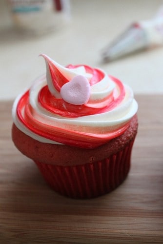 Gluten-free cupcake with frosting swirl and pink sugar heart.