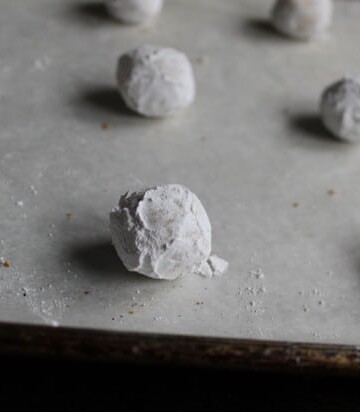 Easy gluten-free Christmas cookie dough coated with powdered sugar on a baking sheet.