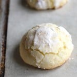 Easy gluten-free Christmas cookie coated with powdered sugar on a baking sheet.