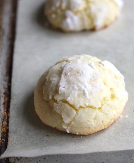 Easy gluten-free Christmas cookie coated with powdered sugar on a baking sheet.