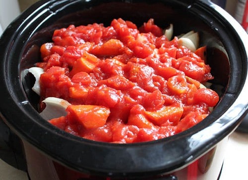 Paleo pot roast in slow cooker topped with canned tomatoes.