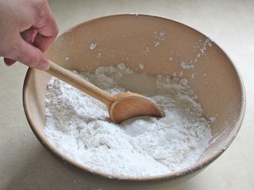 Gluten-Free Flour Tortilla dough being mixed with wooden spoon.