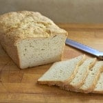Gluten-free loaf of bread sliced on a cutting board.