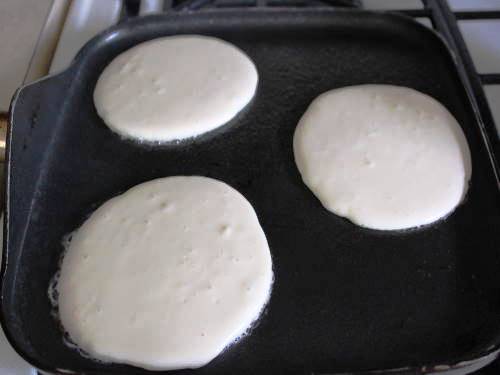 Gluten-free pancake batter on skillet.