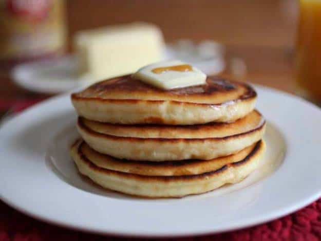 Fluffy Gluten Free Pancakes with a pat of butter and drizzle of syrup.