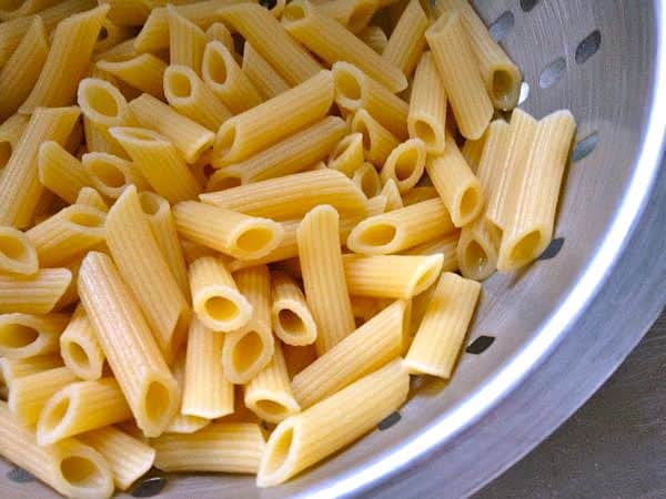 Cooked gluten-free pasta in a strainer.