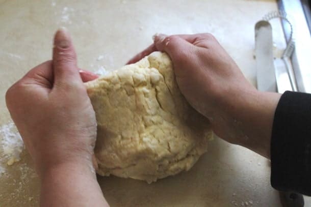 Kneading gluten-free pizza dough on a counter.