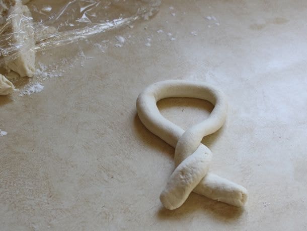 Gluten-Free Soft Pretzel dough being shaped into a pretzel.
