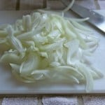 Chopped onions on cutting board.
