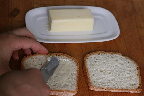 Spreading butter on gluten-free bread.