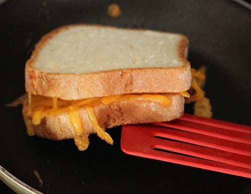 Flipping a gluten-free grilled cheese over in pan.
