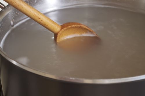 Stirring cooking gluten-free pasta in a pot of water.