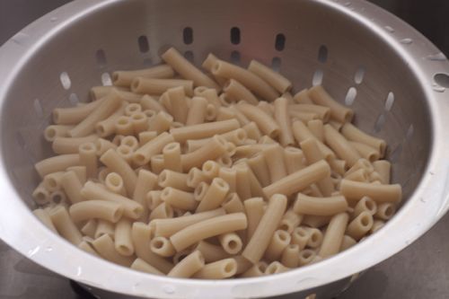Draining gluten-free pasta in a colander.