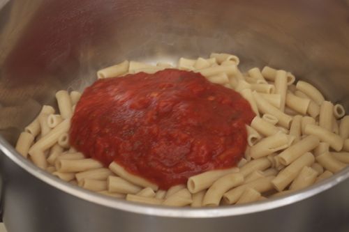 Gluten-free pasta with tomato sauce in pot.
