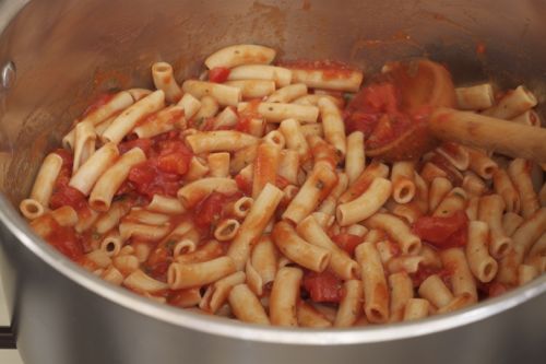 Gluten-free pasta in pot with tomato sauce.