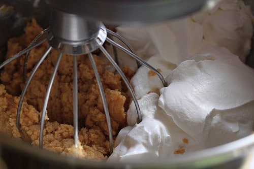 Mixing peanut butter pie filling with cool whip.