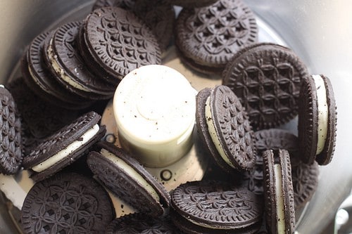 Gluten-free chocolate sandwich cookies in food processor bowl.