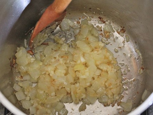 Stirring cooked onion in a pot.