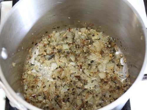 Cooked onions, garlic, herbs, and melted butter in a small pot.