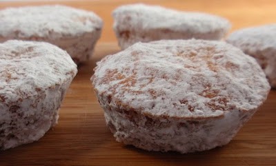 Powdered Sugar Doughnut Muffins on a wood board.