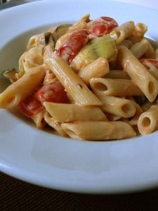 Cooked gluten-free pasta with cream sauce in white bowl.