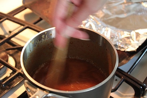 Stirring caramel sauce in pan.