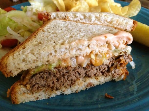 Burger on gluten-free bread with special burger sauce and melted cheese.