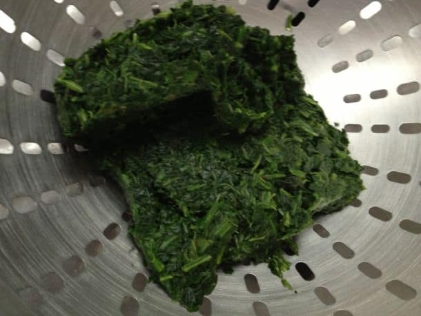 Draining liquid from chopped spinach.