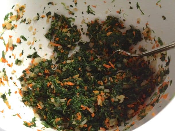 Spinach, carrots, and onions in a bowl.