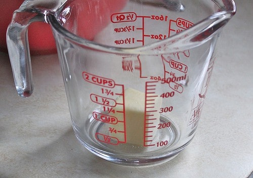 Butter in measuring cup for steamed potatoes.
