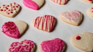 Gluten-free sugar cookie hearts frosted with pink and red chocolate.