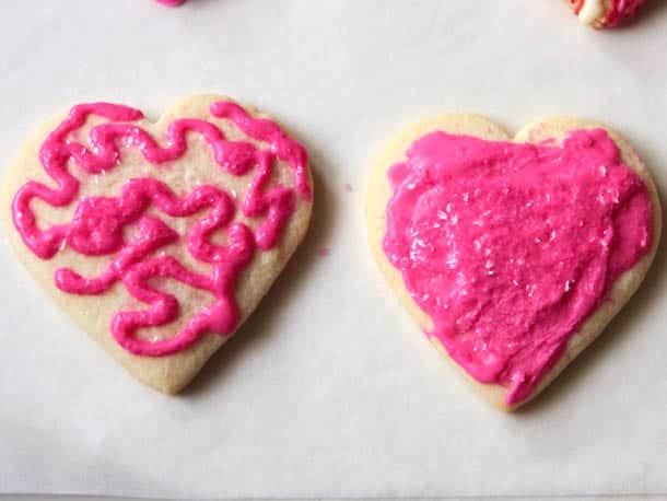 Gluten-free sugar cookies decorated with pink frosting.