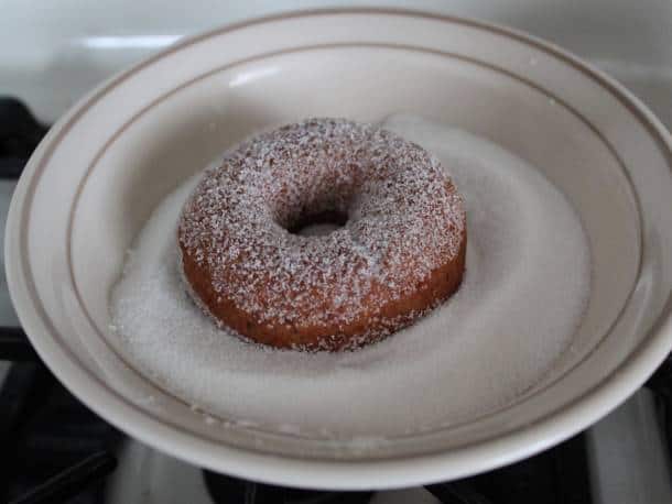 Gluten-Free Vegan Apple Cider Doughnuts on a plate with sugar.
