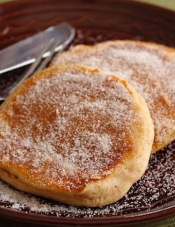 Apple Cider Doughnut Pancakes on a plate coated with granulated sugar.