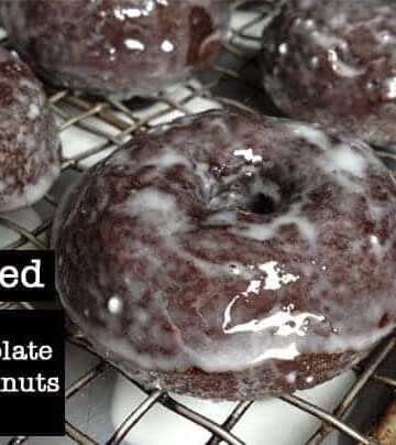 Baked gluten-free chocolate doughnuts on wire rack.