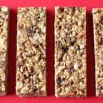 Chewy granola bars on red cutting board.