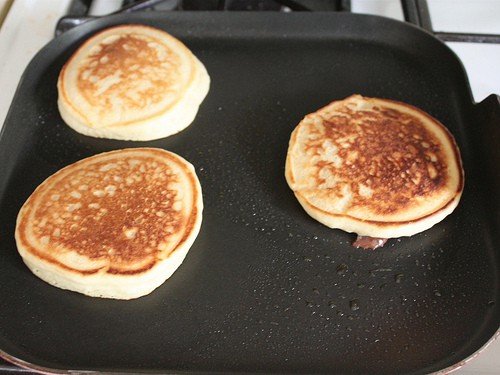 Cooked gluten-free chocolate chip pancakes on a griddle.