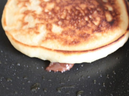 Melted chocolate chip oozing from chocolate chip pancake.