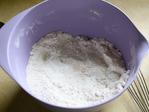 Gluten-free flour mixture for chocolate chip pancakes in purple bowl.