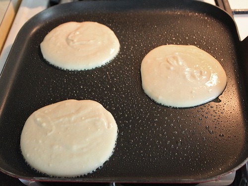Gluten-free pancakes on greased griddle.
