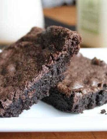 Two gluten-free brownies on a white platter.
