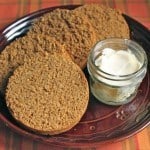 Gluten-Free Boston Brown Bread sliced on a plate with a dish of butter.