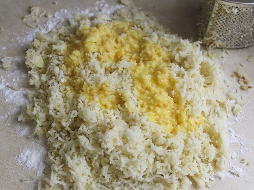 Grated potatoes and whisked egg mixture on the counter.